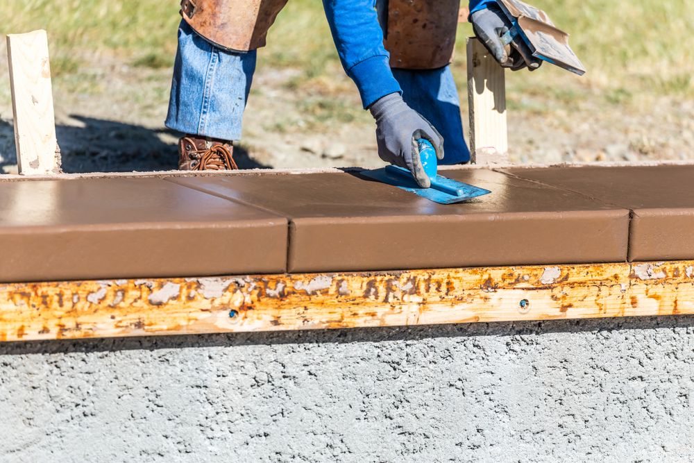 Construction Worker Using Trowel On Wet Cement Forming Coping Around New Pool