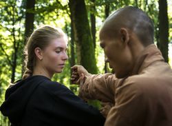 Cheerful woman practicing martial arts with trainer