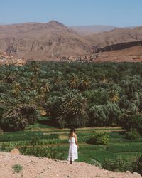 Woman in white against tropical garden