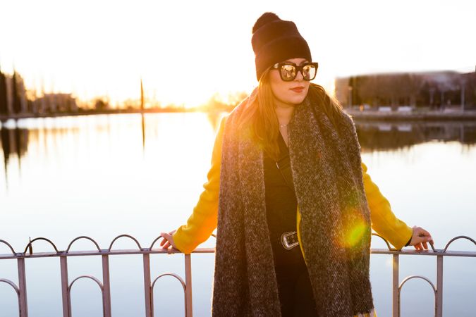 Charming woman in casual wear on shore of lake