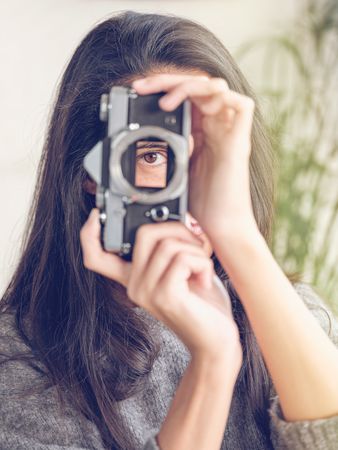 Woman photographing on retro photo camera