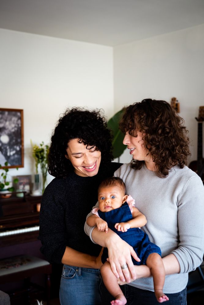 Happy couple looking down at their baby in the living room, vertical