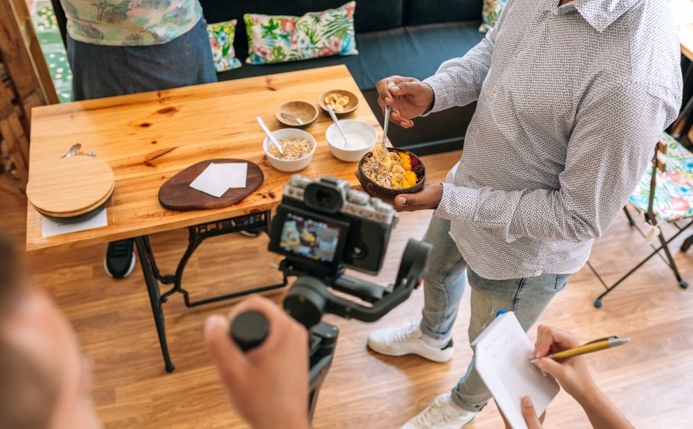 Unrecognizable camera operator recording a streaming cooking tutorial.
