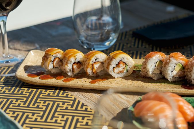 Sushi set served on wooden board with sauce