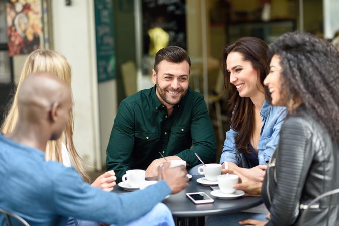 Group of friends having a coffee together at outdoor cafe