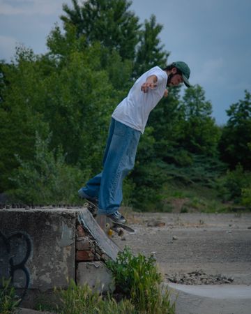 Bearded man in light shirt skateboarding outdoor