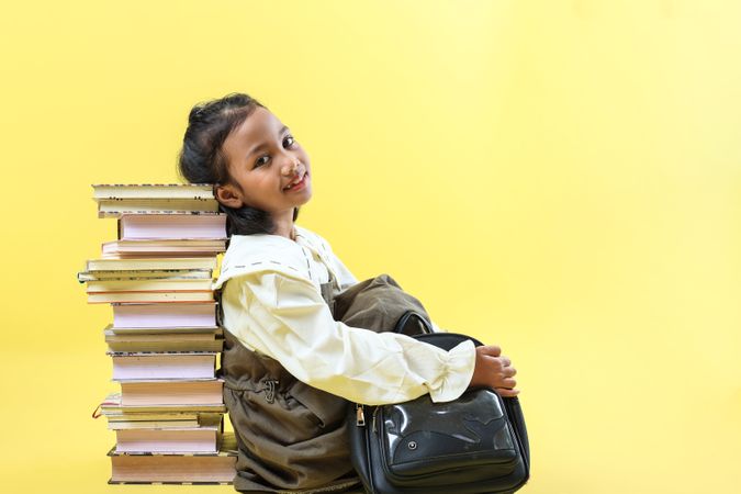 Asian Girl Sitting and Leaning on Stacked Books