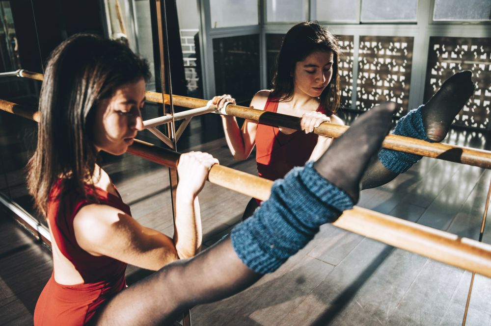 Stretching ballerina in studio