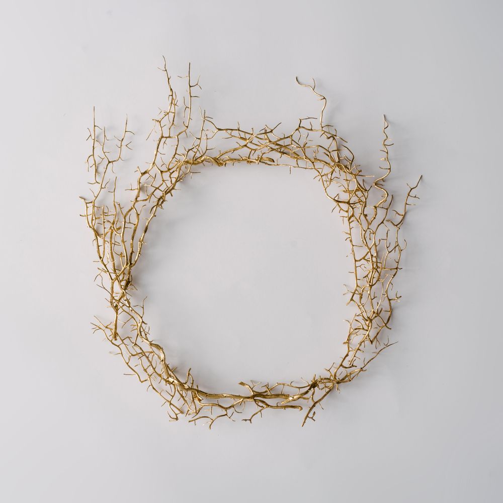Thorny wreath made of branches on light background
