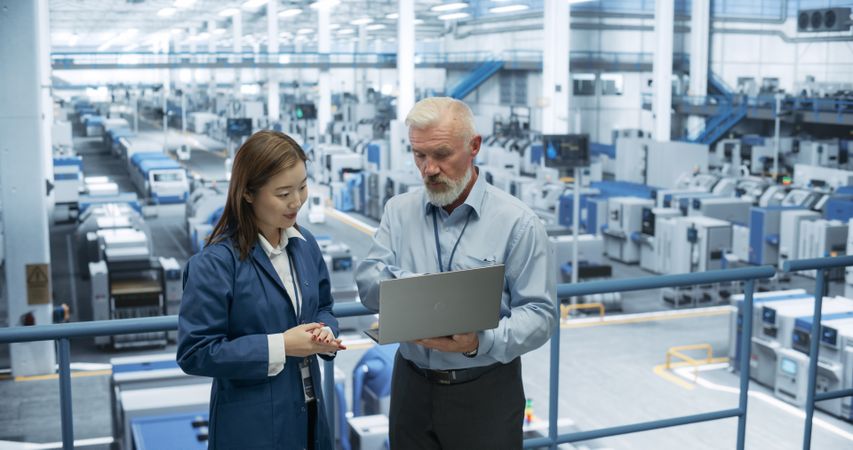 Experienced Mature Engineer Giving an Electronics Factory Tour to Young Japanese Student. Asian Female with Technical Background Asking Questions About Production, Manufacturing, Research
