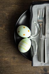 Top view of pastel green eggs on dark plates for Easter dinner