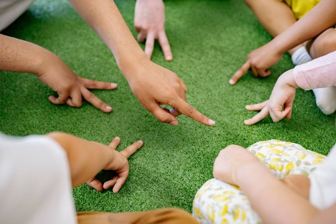 Cropped image of group of kindergarten children sitting in circle