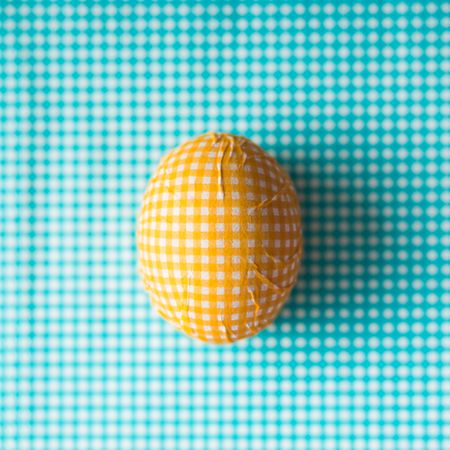 Yellow checkered Easter egg with blue background
