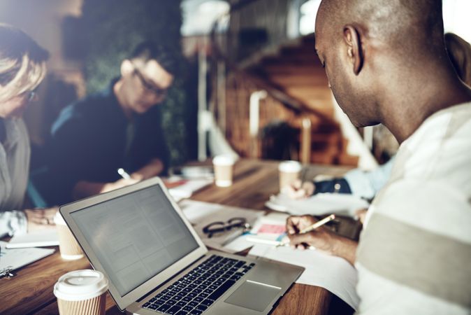 Group of colleagues working together on table in open office