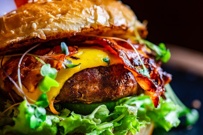 Close up of hamburger with cheese, bacon and lettuce