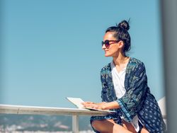 Smiling woman with book chilling on balcony
