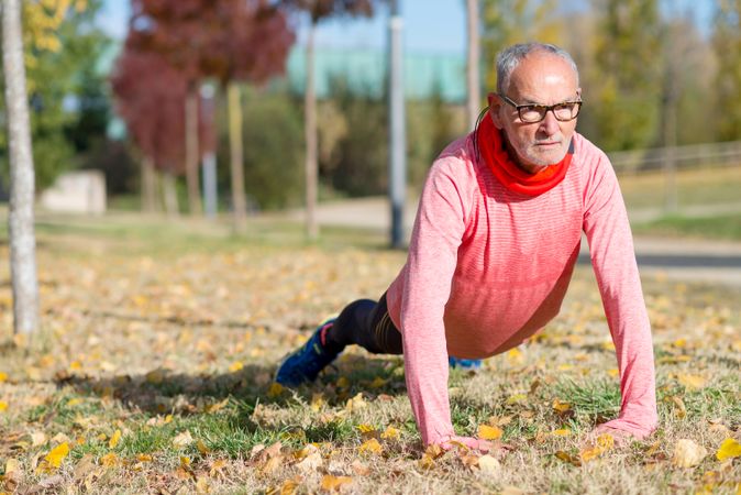 Male doing plank on the grass in park