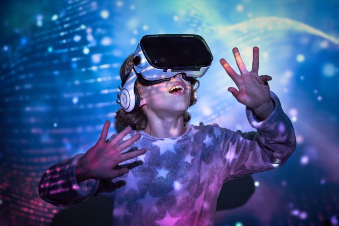 Surprised little boy discovering cyberspace in VR headset
