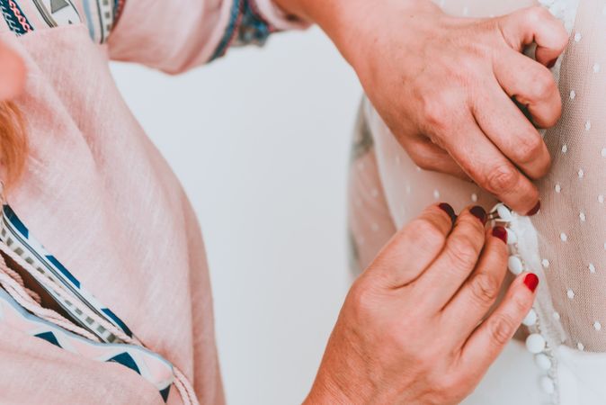 Woman buttoning up wedding dress