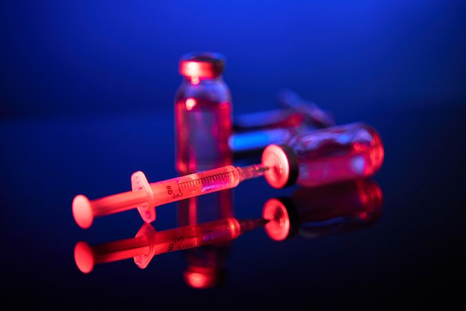 Syringes and vaccine ampoules in blue room