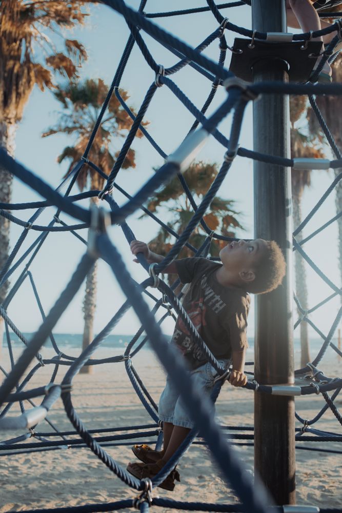 Funny Black boy on net on playground