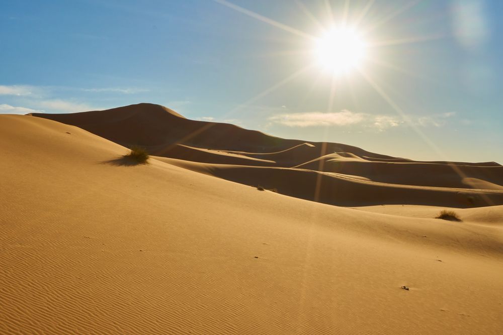 Sand dunes and blue sky with sun