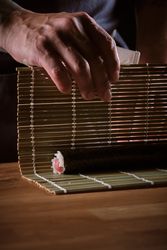 Male shushi man hands preparing different pieces of makis