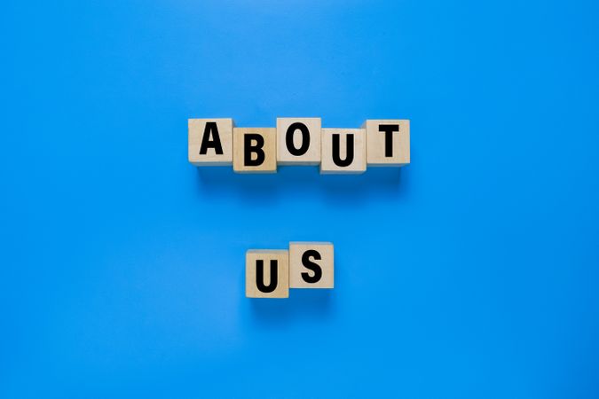 about us words on wooden blocks isolated on blue background
