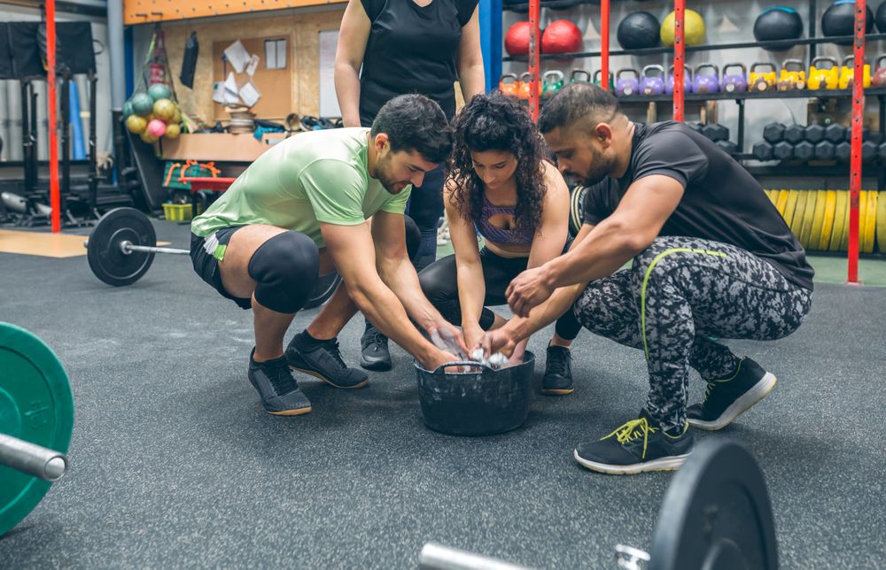 Gym mates applying magnesium to practice weightlifting
