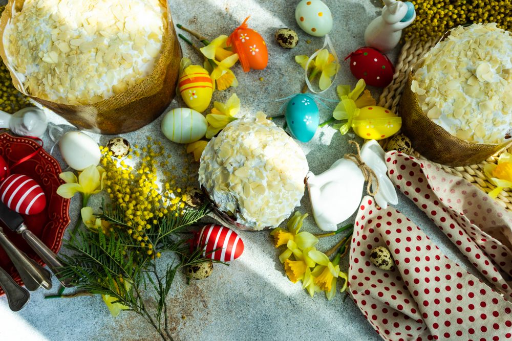 Top view of Easter food concept with iced cakes, Easter eggs and spring flowers