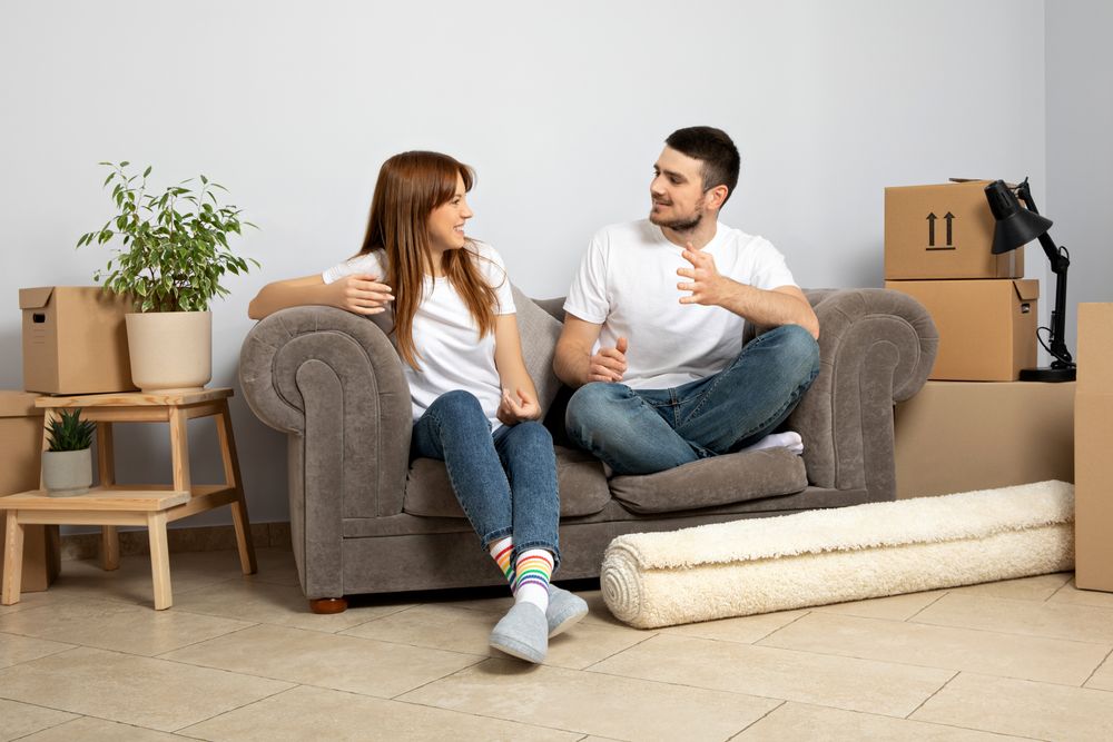 Moving concept, couple man and woman with boxes in apartment.