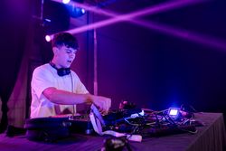 Young DJ working on mixing board