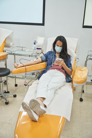 Female patient giving blood in clinic