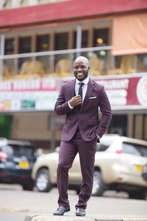 Man in purple suit standing on street