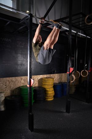 Strong sportsman doing exercise on bar