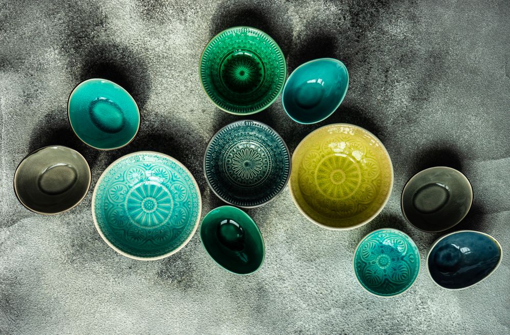 Empty colorful bowls on stone background