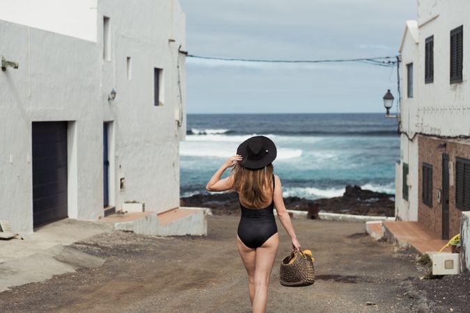 Anonymous female on small street of coastal town
