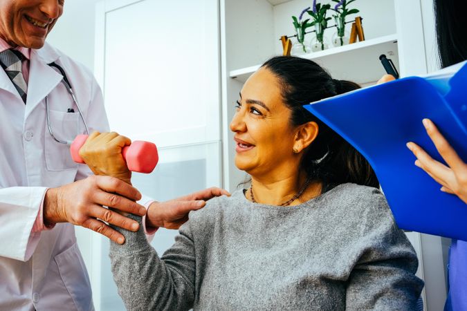 Close up of patient working through arm rehab exercises with doctor