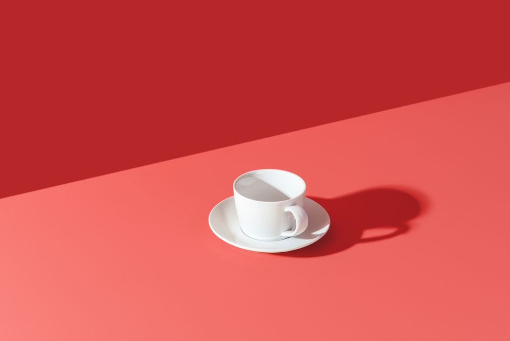 Cup in bright light isolated on a pink background