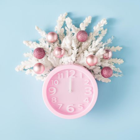 Pink clock, snowy branches and Christmas baubles