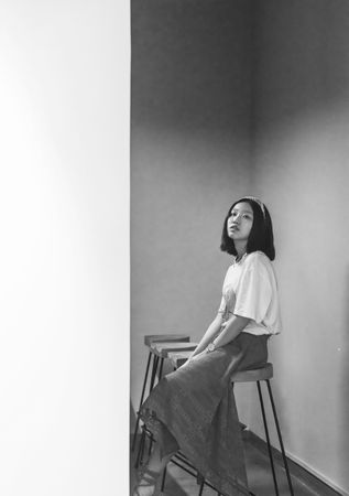 Greyscale photography of woman sitting on chair indoor