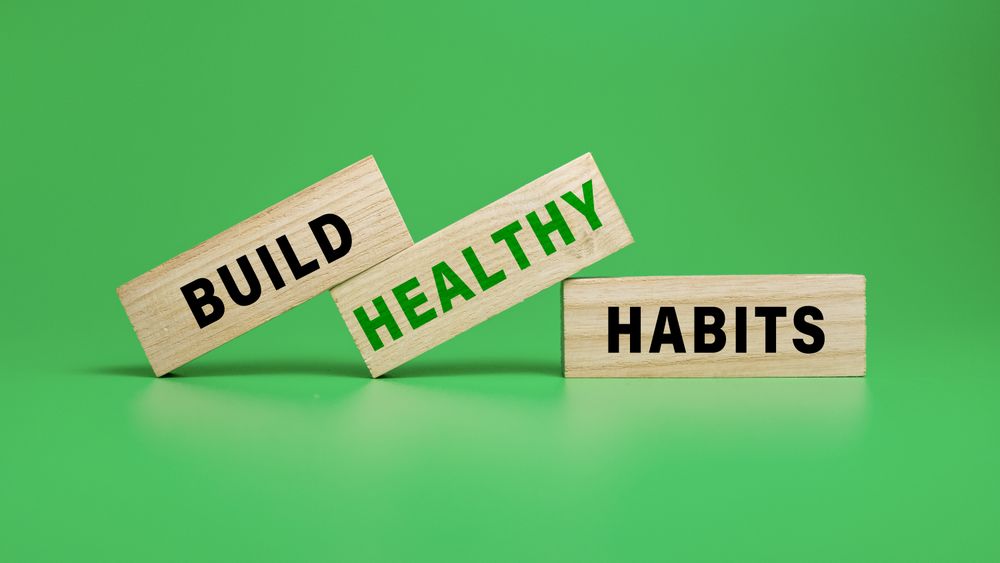 build healthy habits on wooden blocks isolated on green background
