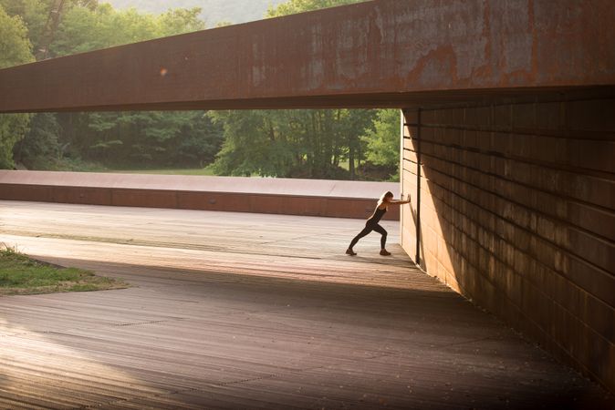 young woman stretching leaning in a amazing geometrical building