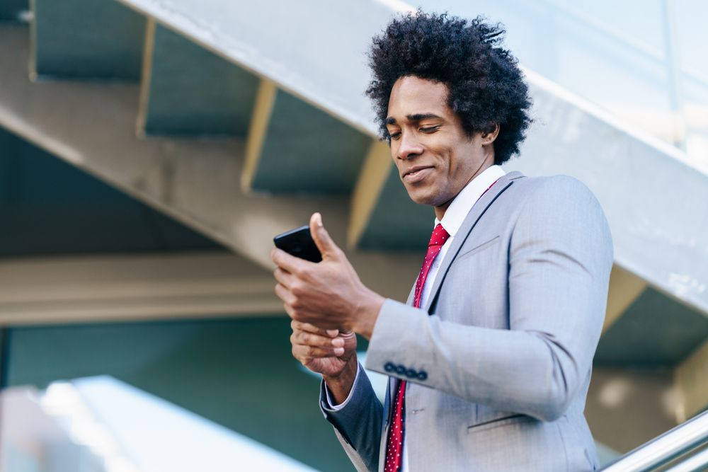 Man outside checking his phone on staircase