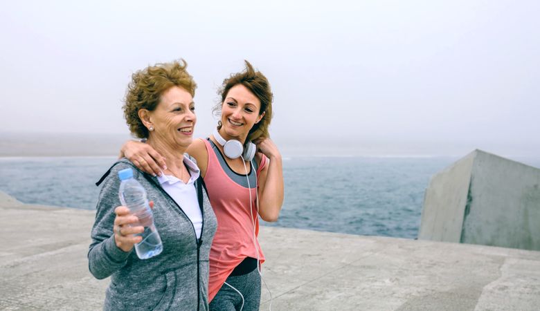Two women walking by sea pier