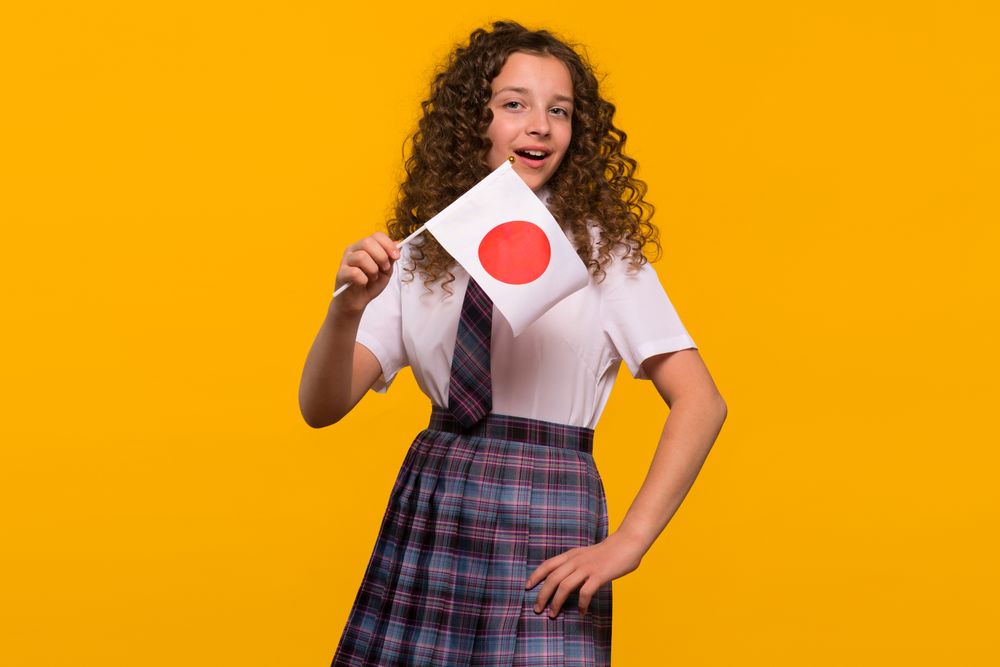 Cheerful girl holding Japanese flag