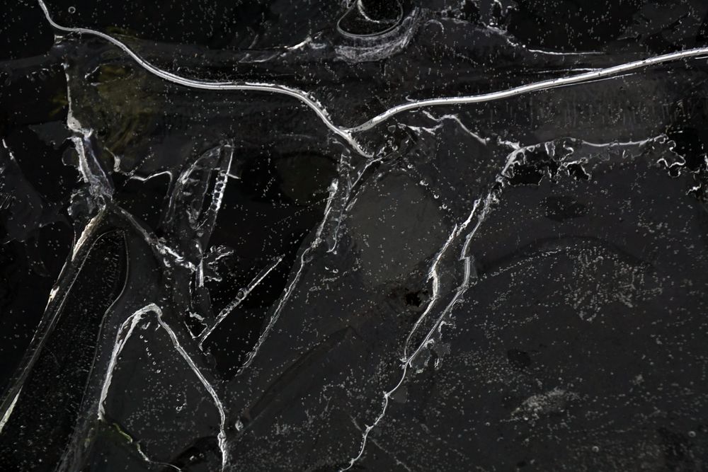 Fragment of thin ice on dark frozen river