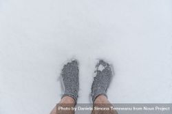 A man’s feet in socks standing on snow, above view 5nZ3Q5
