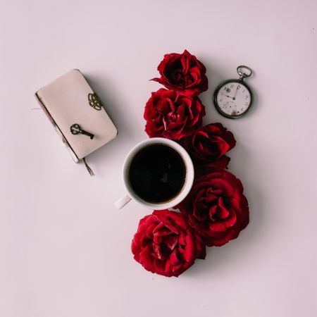 Flower coffee cup with roses,  book, key and watch