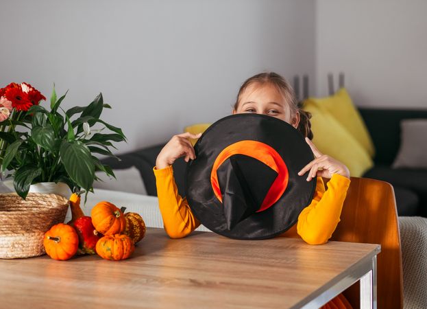 Little Girl Playing With a Pumpkin. emotional portrait  at home. Halloween party concept.